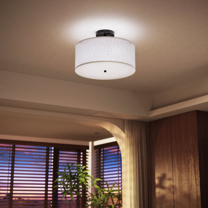  Side view shows linen drum shade, matte black metal base, and white diffuser panel with center finial