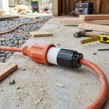 Orange extension cord with black connector on a construction site background
