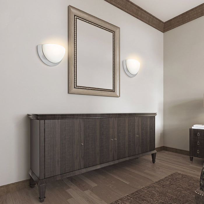 Brushed-nickel bowl wall sconces around bathroom mirror