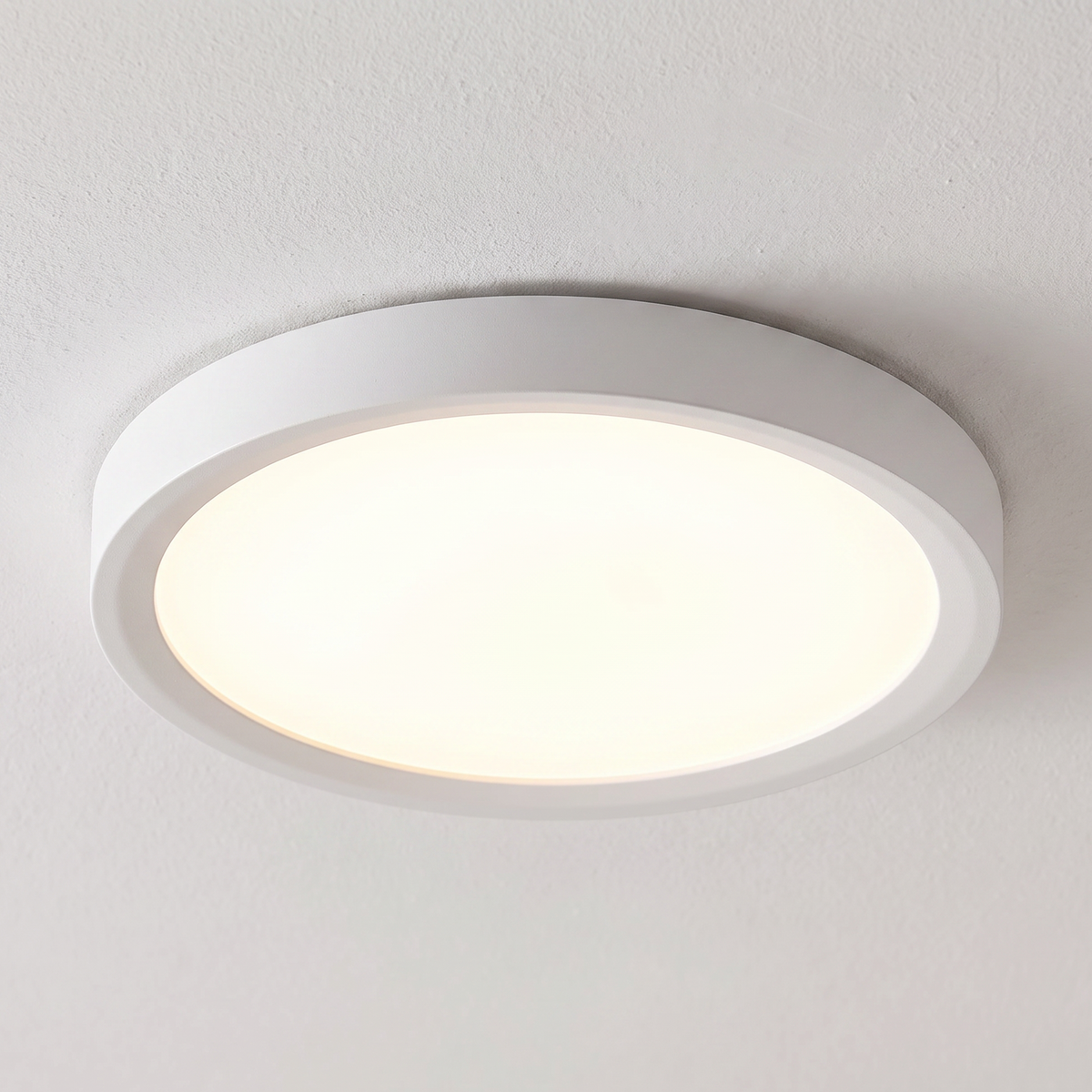 White round flush-mount ceiling light installed illuminated
