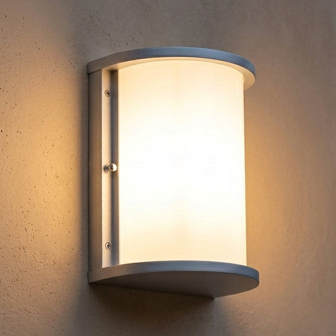 Brushed-nickel half-cylinder wall sconce installed illuminated