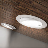Seen on edge, the IC Rated Slim Gimbal with flexible optic is shown here without the included junction box and cabling. You can clearly note the spring clips that hold this thin profile ceiling light in position. The gimbal is adjustable to aim the light where you need it. Choose color temperature from 5 selections of white light with the slider on the junction box (not pictured here). This 6-inch wide downlight is quickly installed in the ceiling and offers instant on, dimmable downlight.