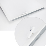 White electronic device on a white surface with a metallic bracket above it.