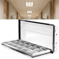 Open 2x4 troffer with parabolic louver hinged down, shown in front of a hallway with ceiling troffers