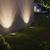 Sunco low voltage in-ground light lights up the exterior sides of buildings with warm light.
