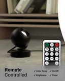 Black spherical lamp with remote control on a surface