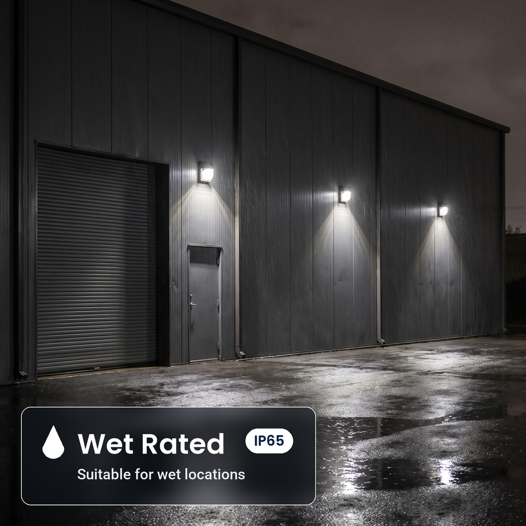 Wet rated, IP65 bronze LED security wall packs with battery backup on a warehouse wall in the rain