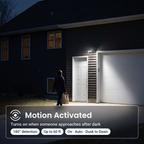 Black two-head LED security floodlight turning on as someone walks up the driveway: 180° motion detection up to 60 ft